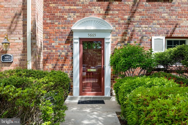 doorway to property featuring brick siding