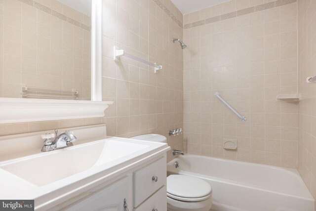 bathroom with vanity, shower / bathing tub combination, toilet, and tile walls