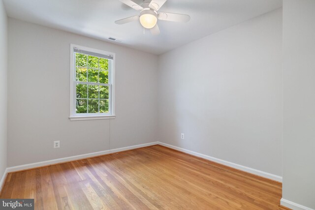 unfurnished room featuring baseboards, visible vents, and light wood-type flooring