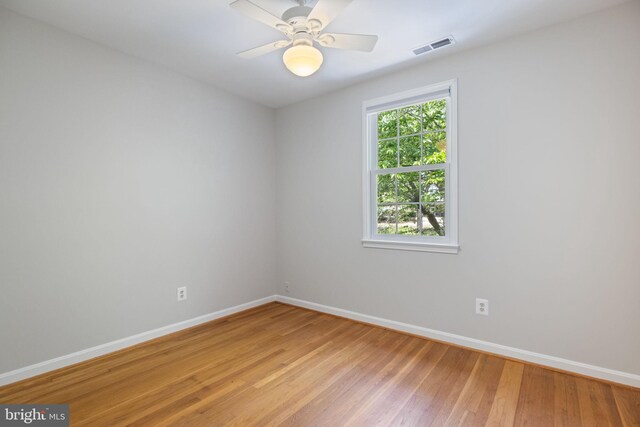 spare room with baseboards, visible vents, ceiling fan, and light wood-type flooring