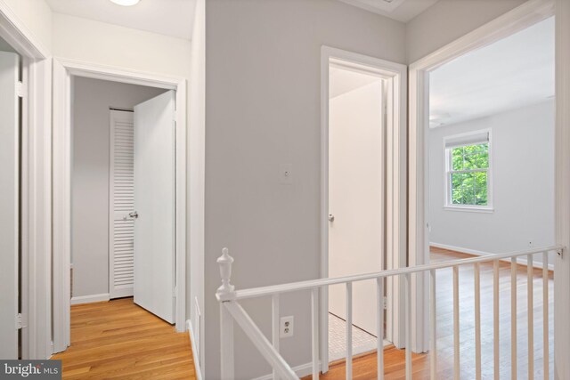 hall featuring light wood-style floors and baseboards