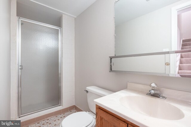 bathroom featuring vanity, a stall shower, and toilet