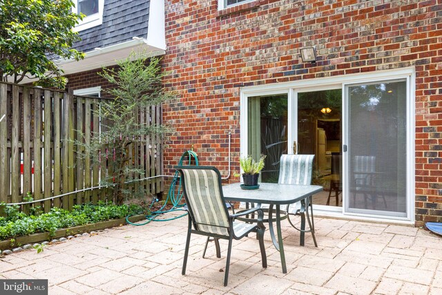 view of patio with outdoor dining area and fence