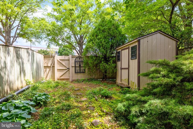 view of shed featuring a fenced backyard and a gate