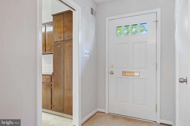 foyer entrance featuring baseboards and visible vents