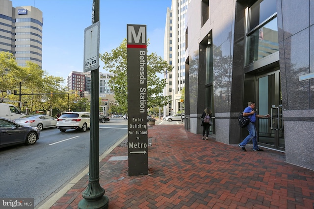 view of street featuring street lighting, traffic signs, sidewalks, and curbs