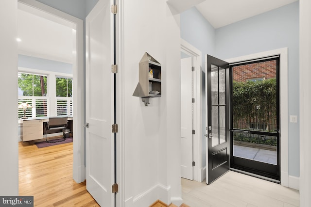 entryway featuring baseboards and light wood finished floors