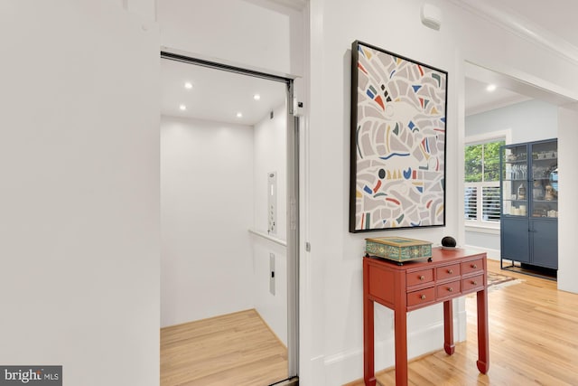 corridor featuring recessed lighting, ornamental molding, and wood finished floors