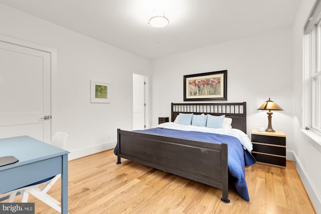 bedroom with baseboards and light wood-type flooring
