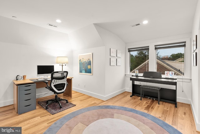 office space with visible vents, baseboards, wood finished floors, and vaulted ceiling