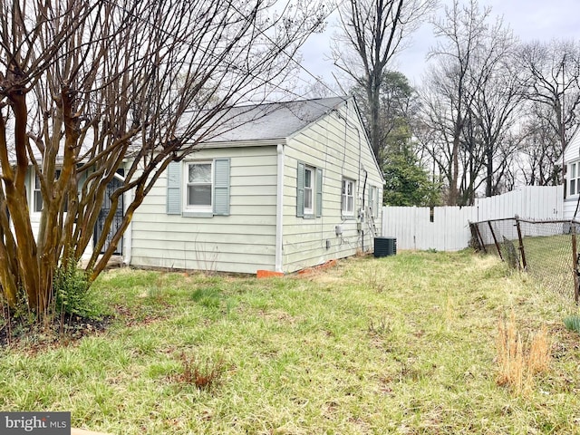 2407 Matthew Henson, Landover, MD 20785 - view of side of home featuring a yard, a shingled roof, central AC unit, and fence