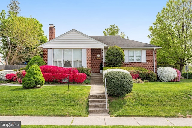 bungalow featuring a front yard, fence, a chimney, and brick siding