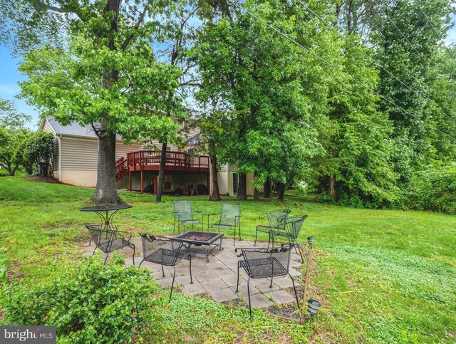 7117 Stanchion Ln, Burke, VA 22015 - view of green lawn with an outdoor fire pit, a deck, a patio, and stairs