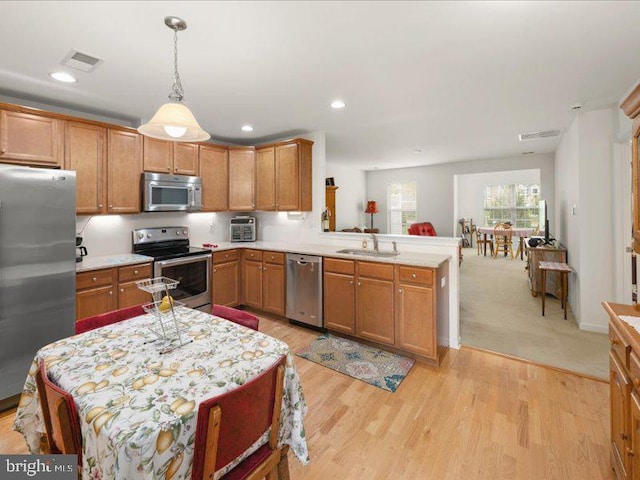 139 Gazebo Ln, Middletown, DE 19709 - kitchen featuring a sink, pendant lighting, stainless steel appliances, light countertops, and a peninsula