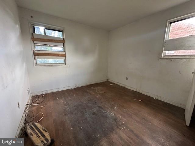 empty room featuring baseboards and wood finished floors