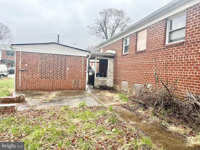 back of property featuring brick siding