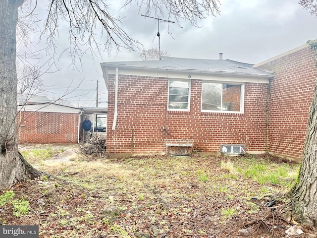 back of house featuring brick siding