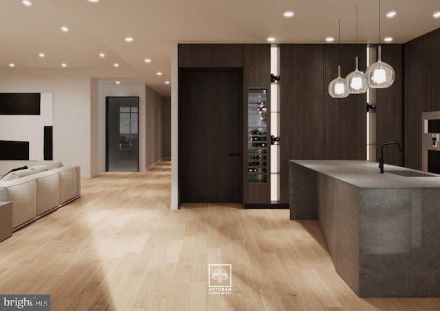 kitchen featuring dark brown cabinets, light wood-style floors, a sink, and modern cabinets