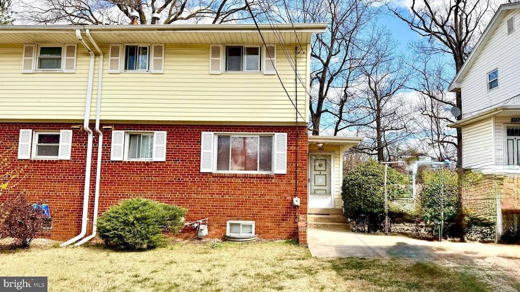 view of home's exterior featuring a lawn, entry steps, and brick siding