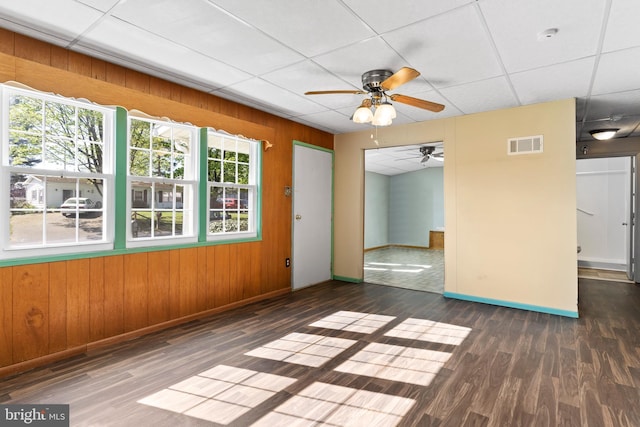 empty room featuring baseboards, ceiling fan, wood finished floors, and visible vents