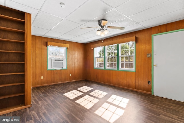 interior space featuring wood walls, ceiling fan, wood finished floors, and cooling unit