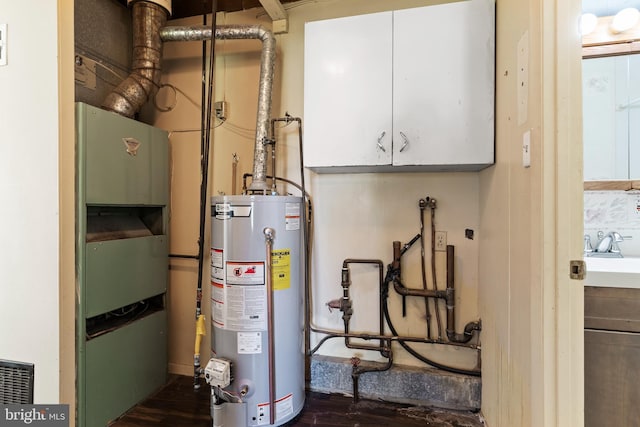 utilities with visible vents, a sink, and water heater