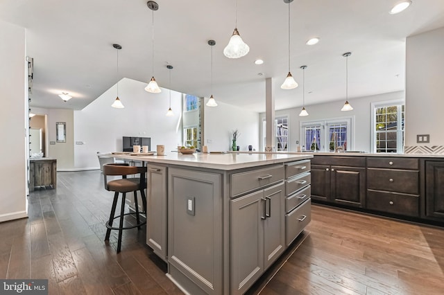3419 Pocahontas Dr, Edgewater, MD 21037 - kitchen with gray cabinets, a breakfast bar area, light countertops, dark wood-style floors, and open floor plan