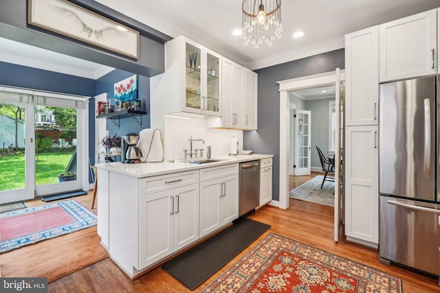3213 Jocelyn St NW, Washington, DC 20015 - kitchen with appliances with stainless steel finishes, light wood-style flooring, ornamental molding, white cabinetry, and recessed lighting