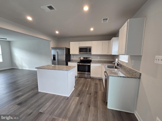 kitchen with light stone countertops, appliances with stainless steel finishes, a sink, and visible vents