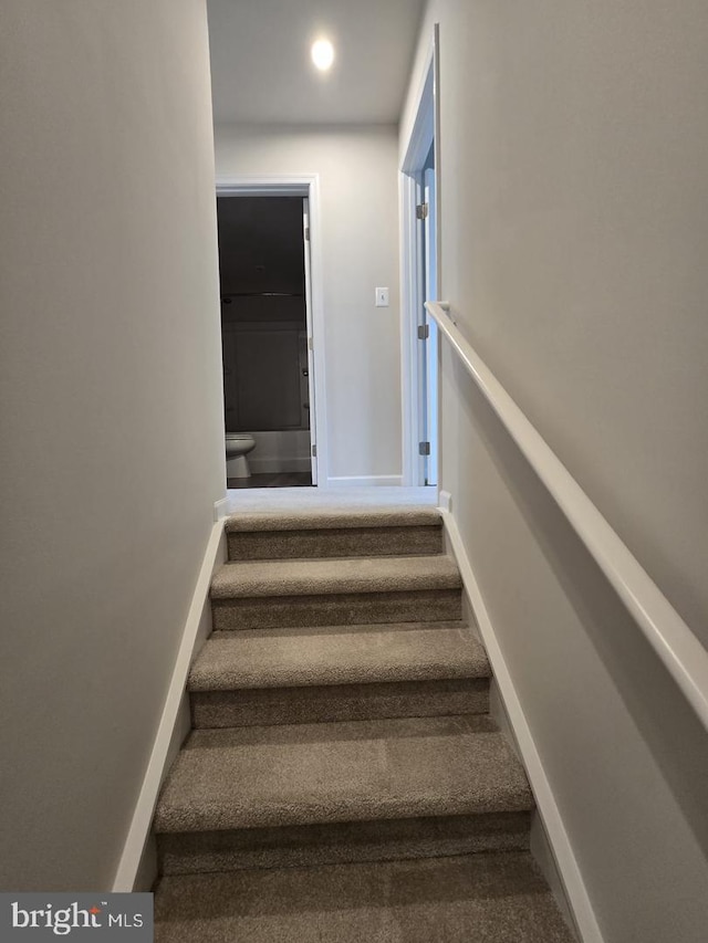 stairs featuring baseboards and carpet flooring