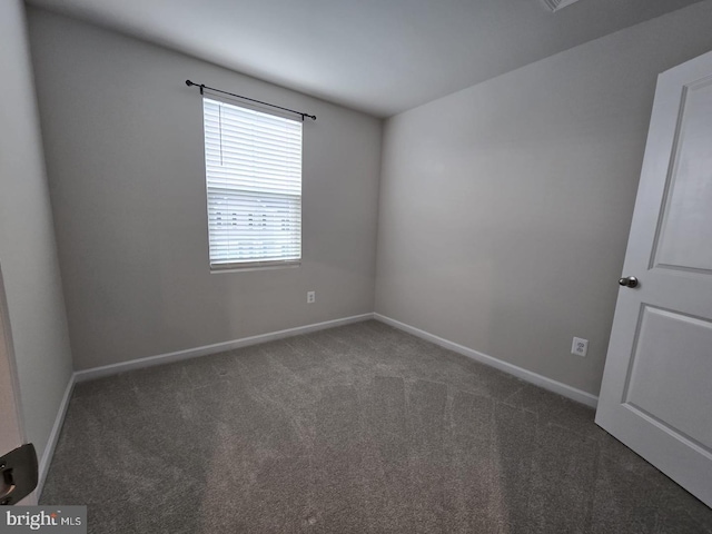 carpeted empty room featuring baseboards