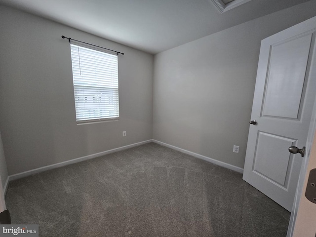 carpeted spare room featuring baseboards