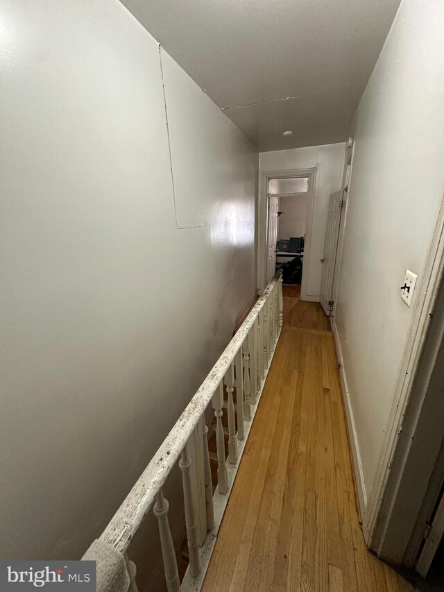 hall with baseboards and light wood-style flooring