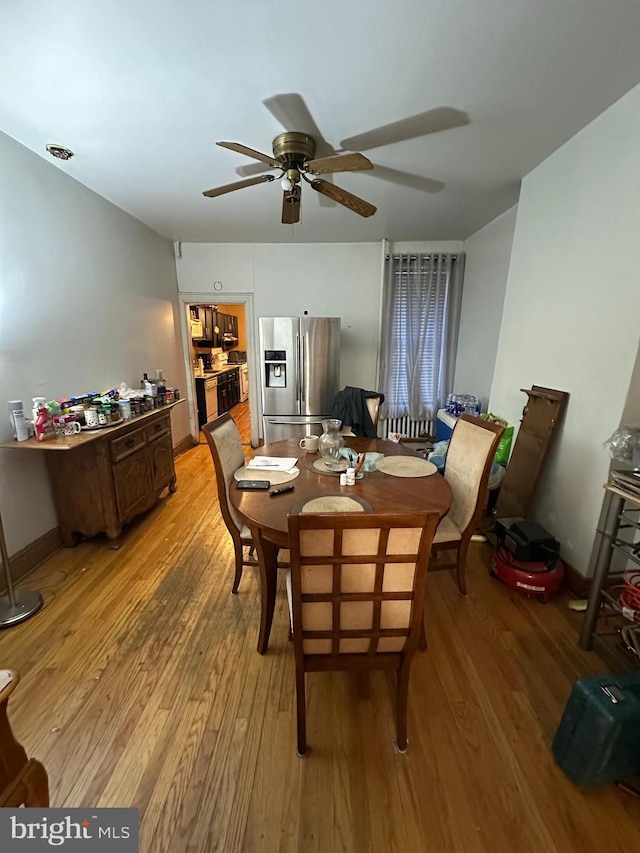 dining area featuring baseboards, ceiling fan, and light wood-style flooring