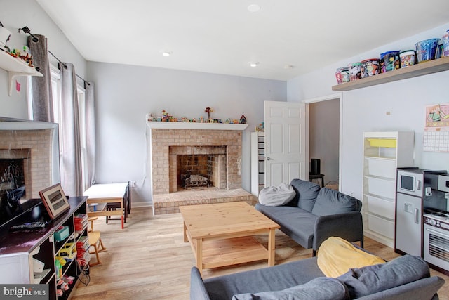 living area with a brick fireplace and light wood-style floors