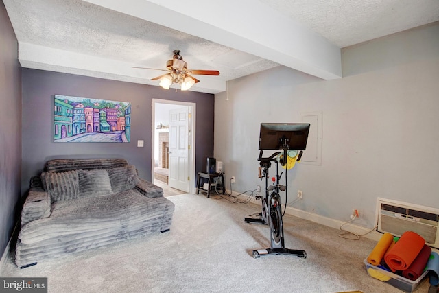 exercise area with a textured ceiling, ceiling fan, carpet, a wall mounted air conditioner, and baseboards