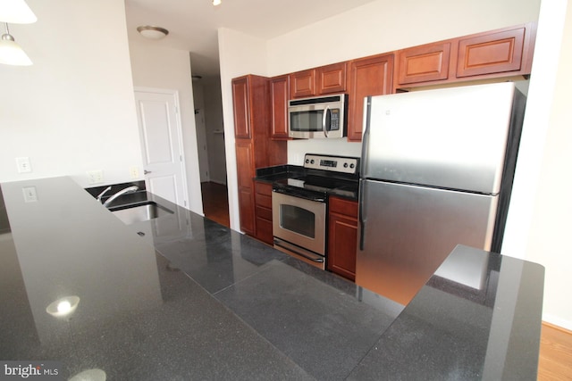 6506 America Blvd Unit 302, Hyattsville, MD 20782 - kitchen featuring dark countertops, decorative light fixtures, a sink, and appliances with stainless steel finishes