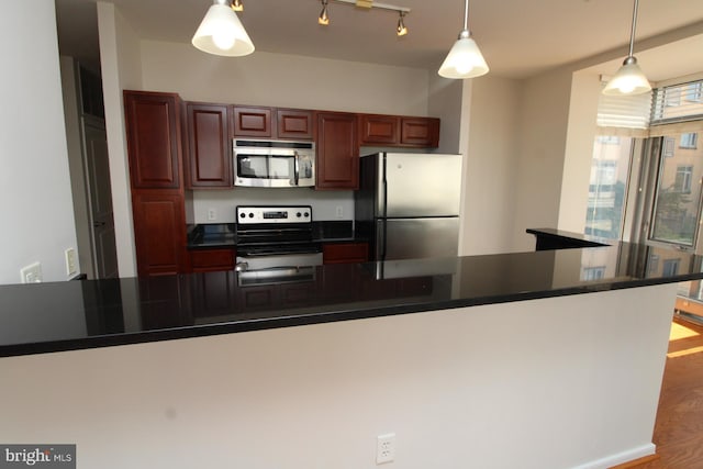 6506 America Blvd Unit 302, Hyattsville, MD 20782 - kitchen with dark countertops, wood finished floors, appliances with stainless steel finishes, and pendant lighting