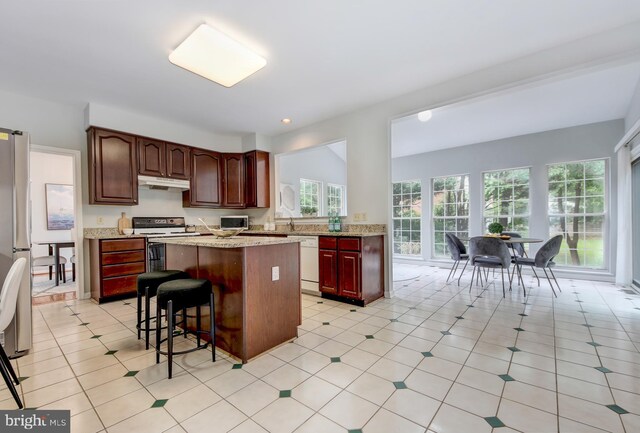 13434 Fairland Park Dr, Silver Spring, MD 20904 - kitchen with electric range oven, under cabinet range hood, white dishwasher, a kitchen island, and a kitchen breakfast bar