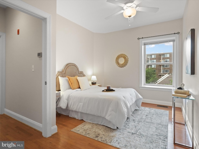 bedroom featuring a ceiling fan, wood finished floors, and baseboards