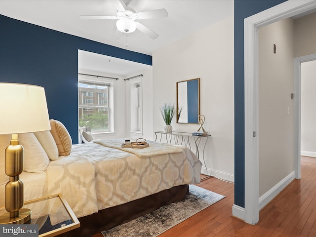 bedroom with baseboards, a ceiling fan, and wood-type flooring