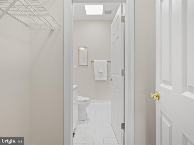 bathroom with tile patterned floors, visible vents, toilet, and baseboards