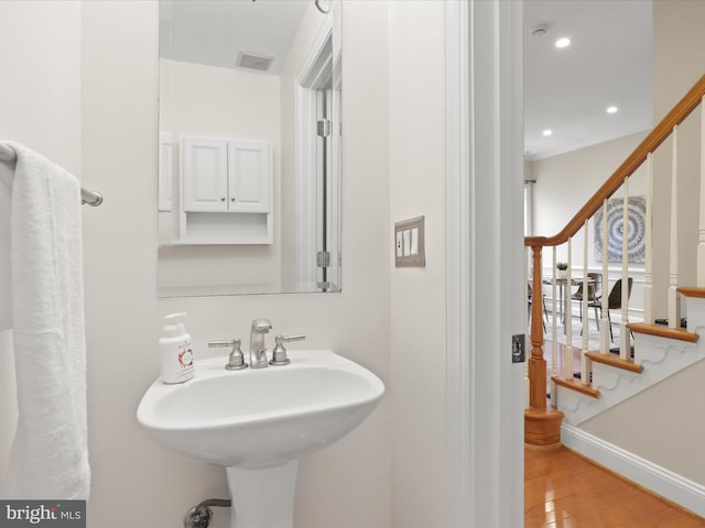 bathroom with a sink, visible vents, baseboards, recessed lighting, and wood finished floors