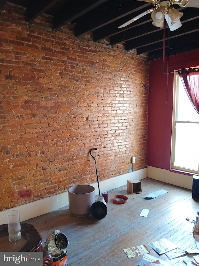 109 N Payson St N, Baltimore, MD 21223 - interior space featuring ceiling fan, wood finished floors, beam ceiling, and brick wall