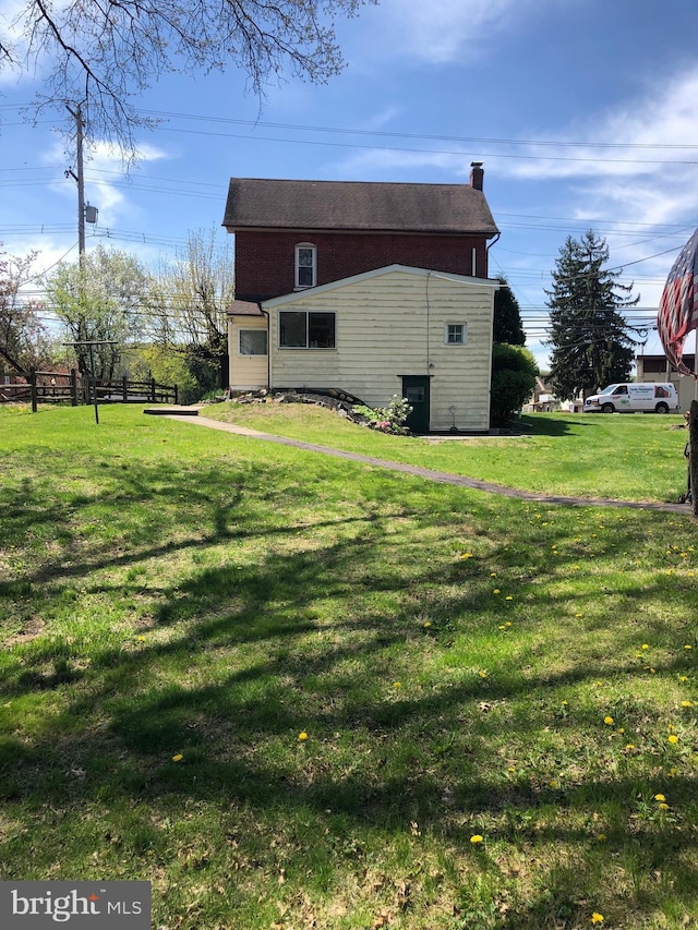 view of property exterior with a lawn and a chimney