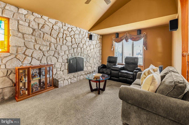 carpeted living room featuring a ceiling fan, vaulted ceiling, and a fireplace