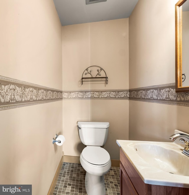 bathroom featuring vanity, toilet, tile patterned floors, a wainscoted wall, and visible vents
