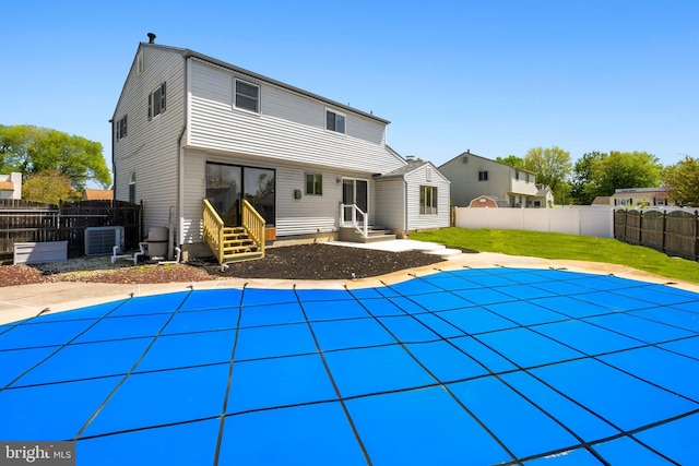 rear view of house featuring a fenced in pool, cooling unit, fence, and entry steps