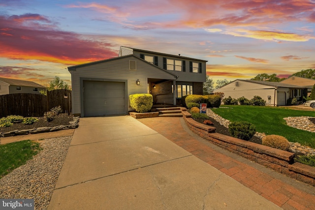view of front of home featuring a garage, fence, a yard, and concrete driveway