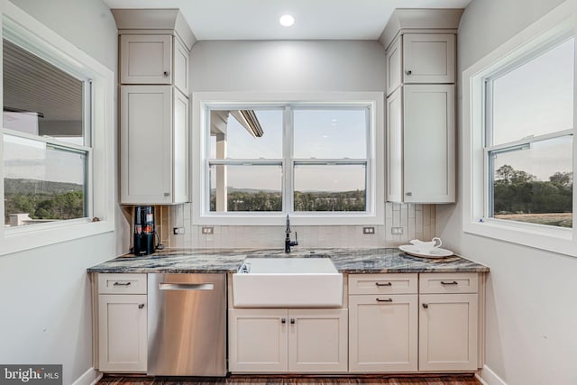 kitchen with dishwasher, a sink, decorative backsplash, and baseboards